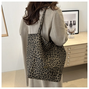 Détail du sac cabas léopard en nylon avec boucle en métal bronze gravée à la main