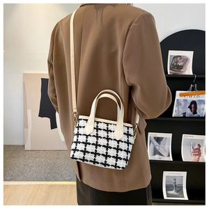 Détail d'un mini sac cabas en tweed à carreaux noir et blanc avec bandoulière blanche