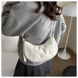 Close-up of a white crescent Hobo bag with visible double stitching and minimalist leather strap