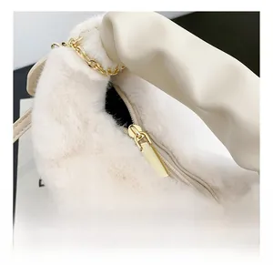 Detail of smooth gold zipper and white faux fur texture on a stylish handbag