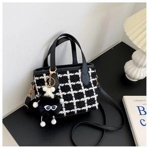 Détail du sac bandoulière en tweed à motif pied-de-poule avec charm monstre en peluche