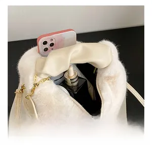 Top view of white faux fur shoulder bag interior showing phone and cosmetics capacity