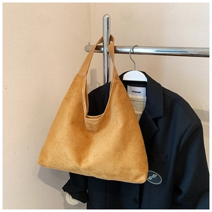 Close-up of textured faux suede bucket bag in earthy brown for daily commuting