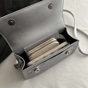 Silver-grey faux leather shoulder bag with textured flap and spacious interior capacity