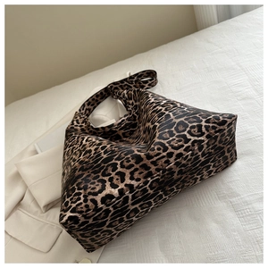 Detail of leopard print tote bag with PU leather texture on white fabric background