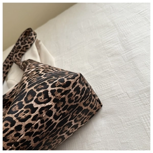 Detail showing the bottom corner and stitching of the leopard print tote bag with wide strap