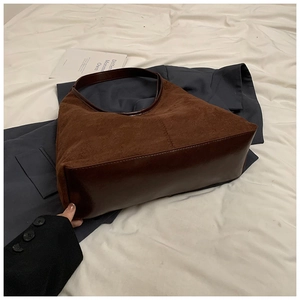 Detail van vintage bruine hobo-tas met suède textuur en stiksels van de leren riem