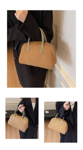 Detailed macro of brown suede Boston bag featuring contrasting green leather top handles