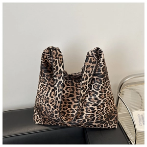 Detail of large capacity leopard print tote bag with wide shoulder straps on a bench