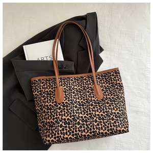 Detail of leopard print tote bag with brown leather handles on a stylish city background