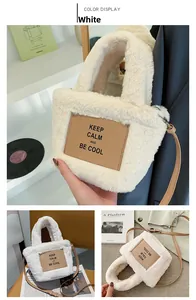 Detail of white plush crossbody bag featuring brown leather patch with text and strap