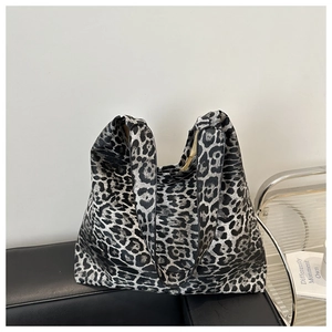 Detail of silver leopard print tote bag on leather sofa for casual daily wear