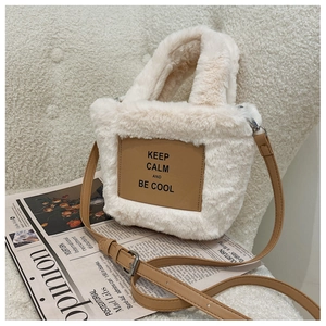 Detail view of plush white faux fur bag with brown leather patch and silver metal hooks