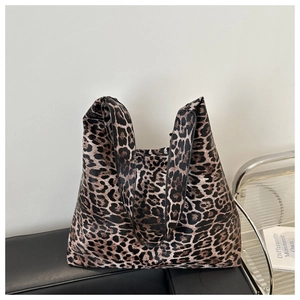 Macro view of leopard print tote bag with thick canvas texture on a black leather seat
