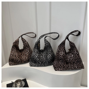 Three leopard print tote bags in brown, silver, and coffee colors displayed on white pedestals