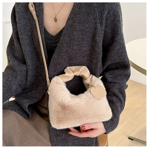 Détail du sac en peluche beige avec poignées en cuir plissé et étiquette de marque