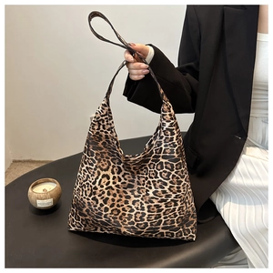 Detailed close-up of a large leopard print tote bag with textured leather and wide strap