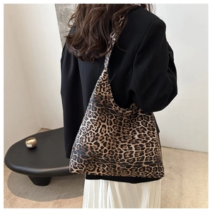 Detailed close-up of a large leopard print canvas tote bag styled on a shoulder