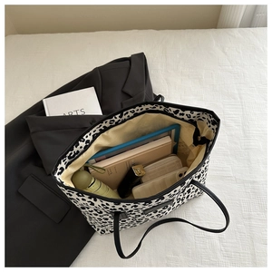 Macro view showing large capacity interior of leopard print tote bag with daily essentials