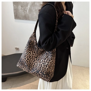 Leopard print tote bag shown as a shoulder bag on a model in a minimalist setting