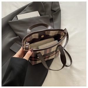 Detail shot showing the large interior capacity of the plaid tote bag with a wallet and phone