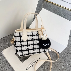 Sac à main en tweed à carreaux noir et blanc avec bordure en cuir et charme peluche