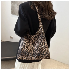 Side view of large leopard print tote bag worn with casual outfit in minimalist setting
