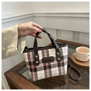 Detail of vintage plaid tote bag featuring brown PU handles and gold rivet accents