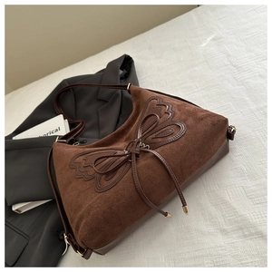 Detailed view of brown suede hobo bag with unique 3D leather butterfly and gold hardware