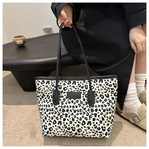 Detail view of large leopard print tote bag with black straps and minimalist aesthetic