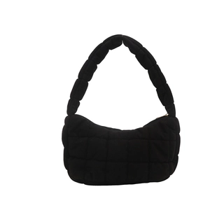 Fashionable black quilted shoulder bag with puffy padded texture and zipper closure