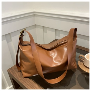 Détail du sac cabas en cuir marron caramel avec texture souple et boucle dorée