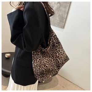 Detailed view of a large leopard print tote bag styled with a minimalist outfit