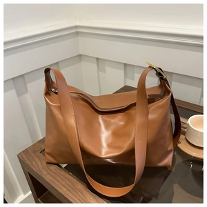 Détail du sac bandoulière marron caramel en similicuir avec fermeture éclair et métal doré