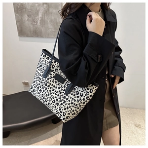 Fashionable leopard print tote bag styled with a black trench coat for a chic daily look