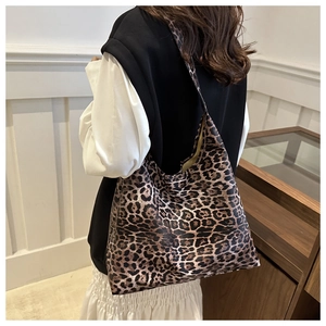 Close-up of a large leopard print tote bag in thick fabric worn over the shoulder