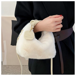 Detail of white plush handbag featuring gold metal chain and 'YOU deserve better' tag