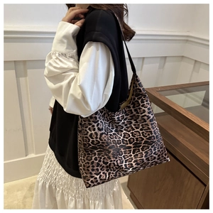 Detailed view of the large capacity leopard print tote bag worn on a woman's shoulder