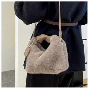 Close-up of brown plush faux fur handbag featuring a knotted leather handle and strap