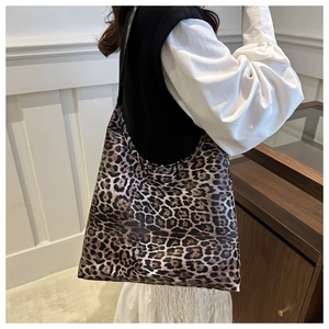 Side view of a large leopard print tote bag with premium leather texture on a female model