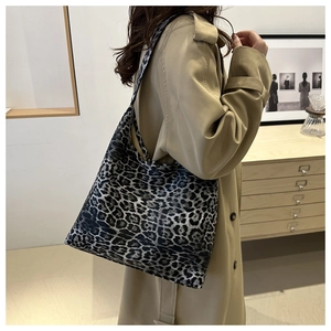 Close-up of leopard print tote bag styled with a beige trench coat for autumn fashion