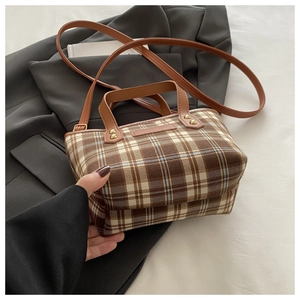Detail of vintage brown plaid tote bag with faux leather handles and gold rivet accents