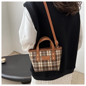 Detail of vintage brown checkered tote bag shown worn by model to display size and scale