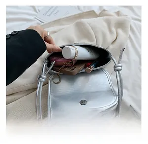 Capacity display of silver metallic crossbody bag showing interior storage and magnetic clasp