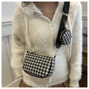 Detail of black and white houndstooth crossbody bag with wide strap and round coin purse