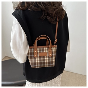 Back view of model wearing a vintage plaid mini handbag with brown leather trim