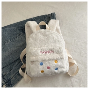 Detail of white plush mini backpack featuring fashion embroidery and colorful buttons