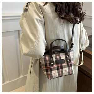 Model view of pink plaid tote bag with brown leather trim and adjustable shoulder strap