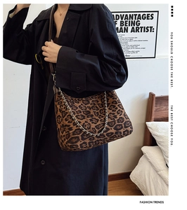 Detailed close-up of leopard print shoulder bag with gold chain and leather strap