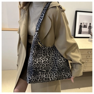 Detailed view of leopard print tote bag styled with a trench coat for a chic look